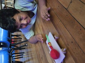 A student observes a small cart with a balloon and straw attached to the top